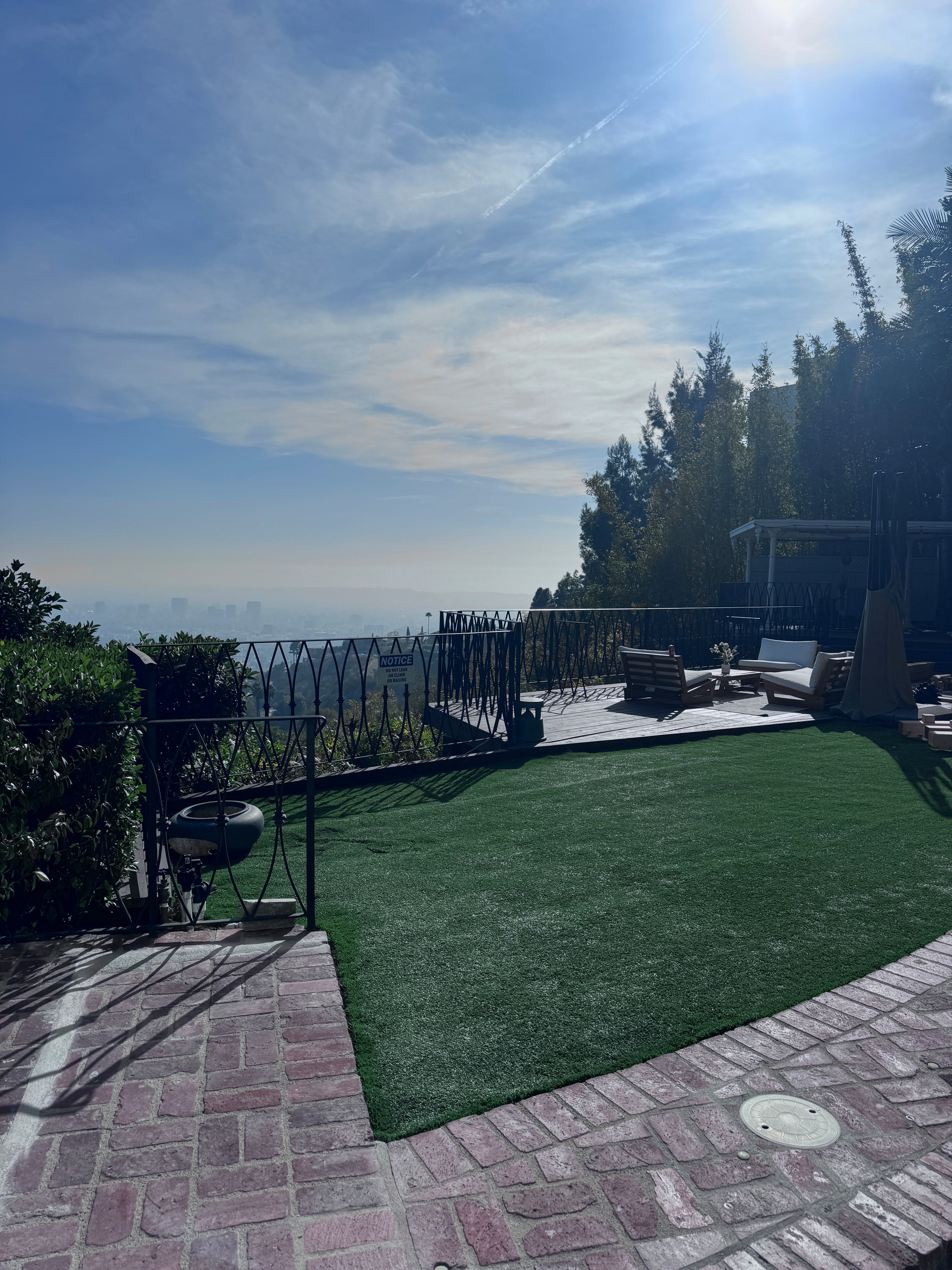 A landscaped outdoor area with artificial grass and a view of the skyline.